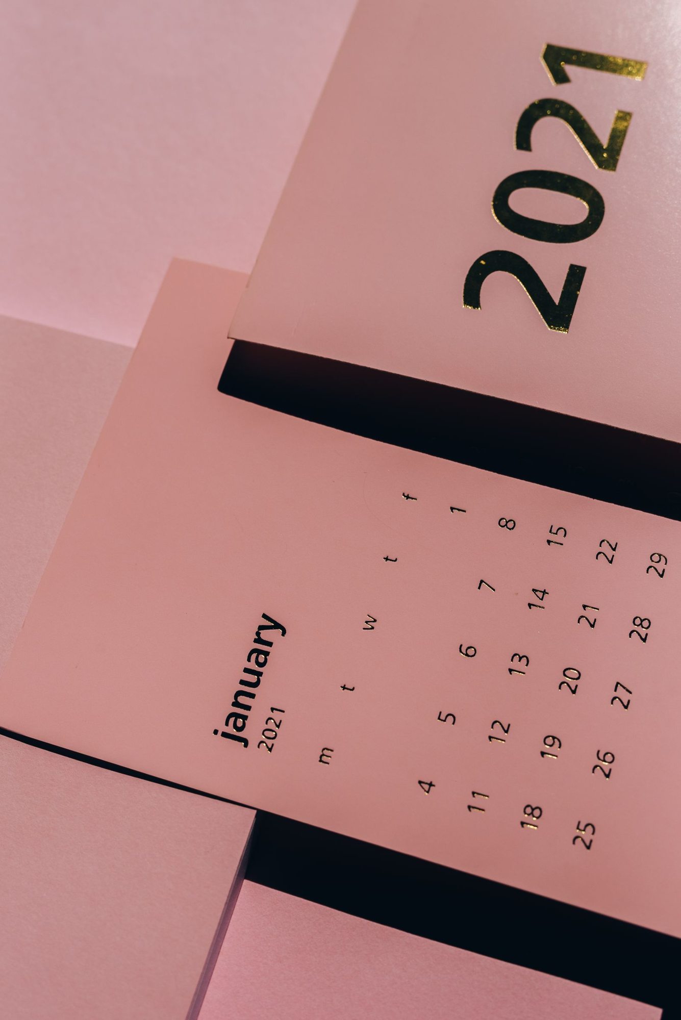 Gedruckter Papierkalender auf rosafarbenem Hintergrund