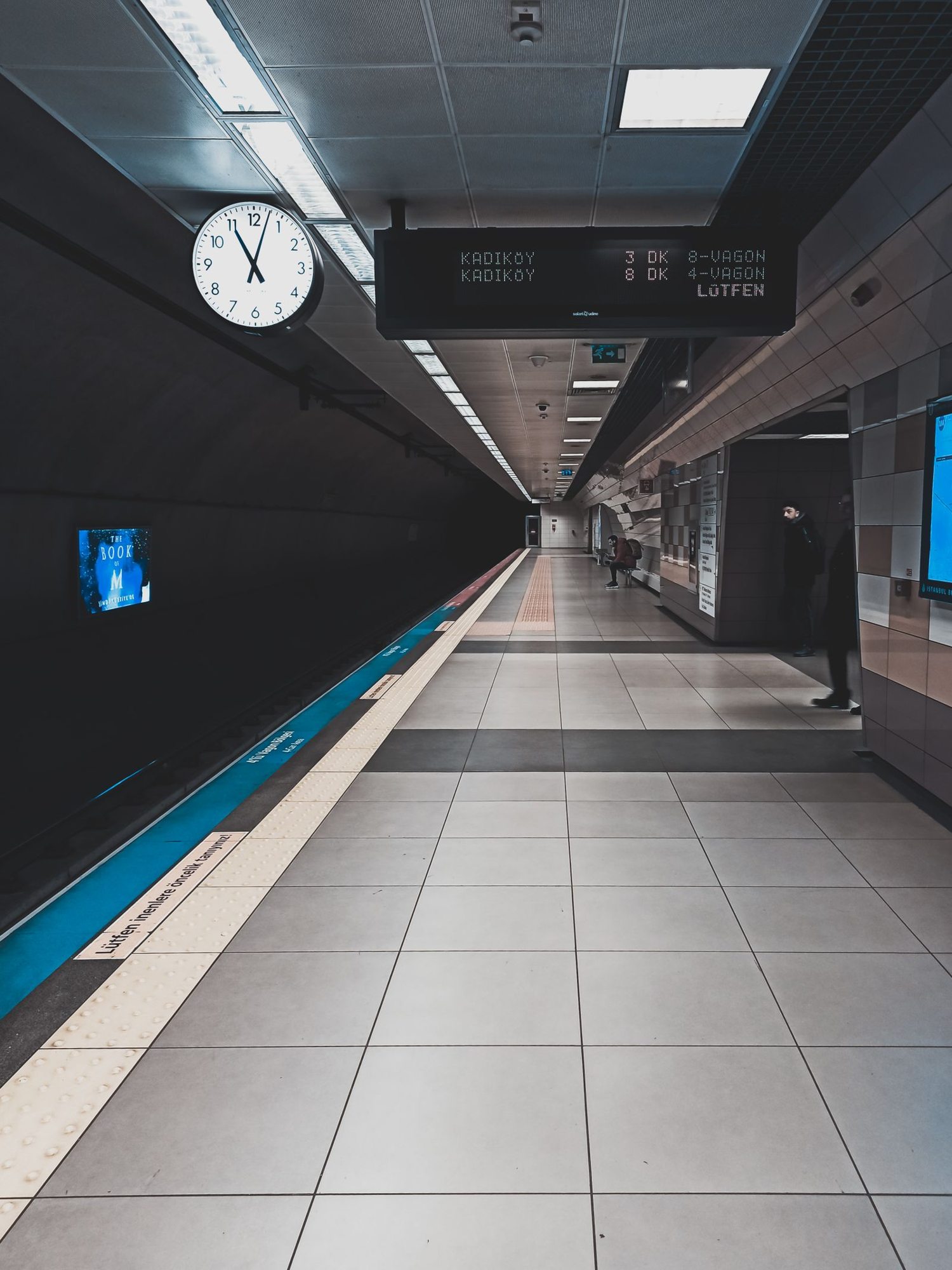 Station clock and signage above a platform
