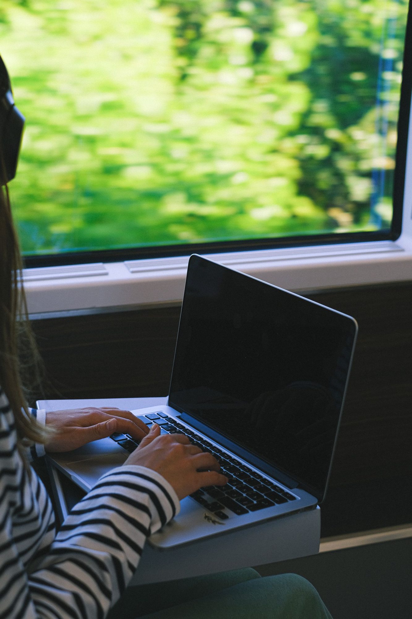 Traveler working on a laptop aboard a train
