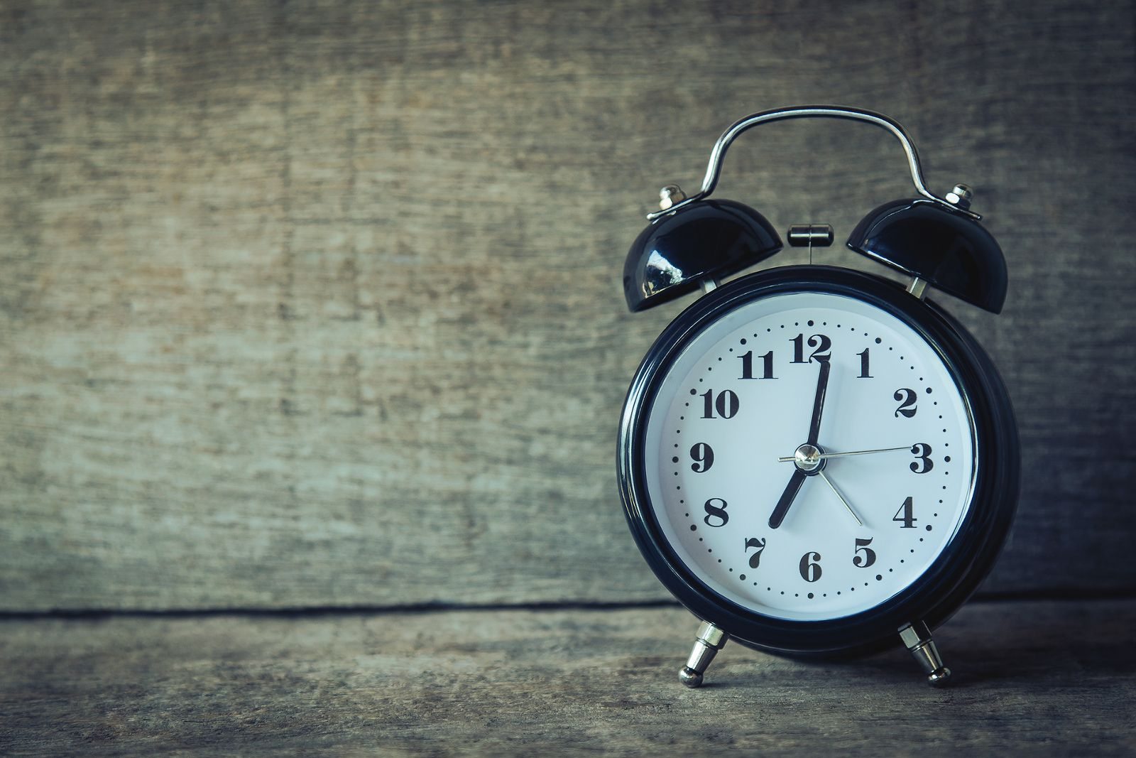 Analog alarm clock on a wooden surface