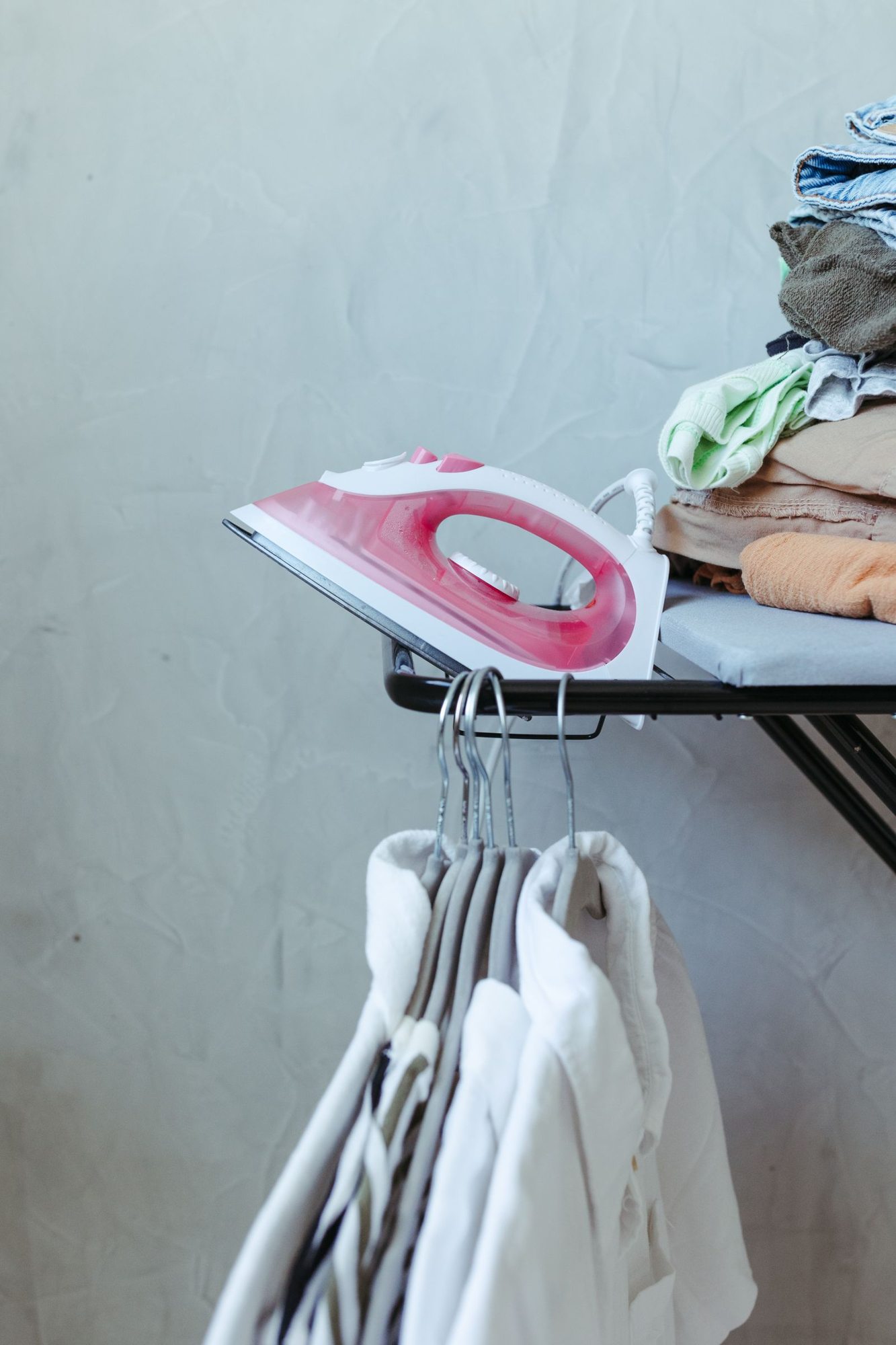 Bügelbrett, Bügeleisen und bereitgelegte Kleidung