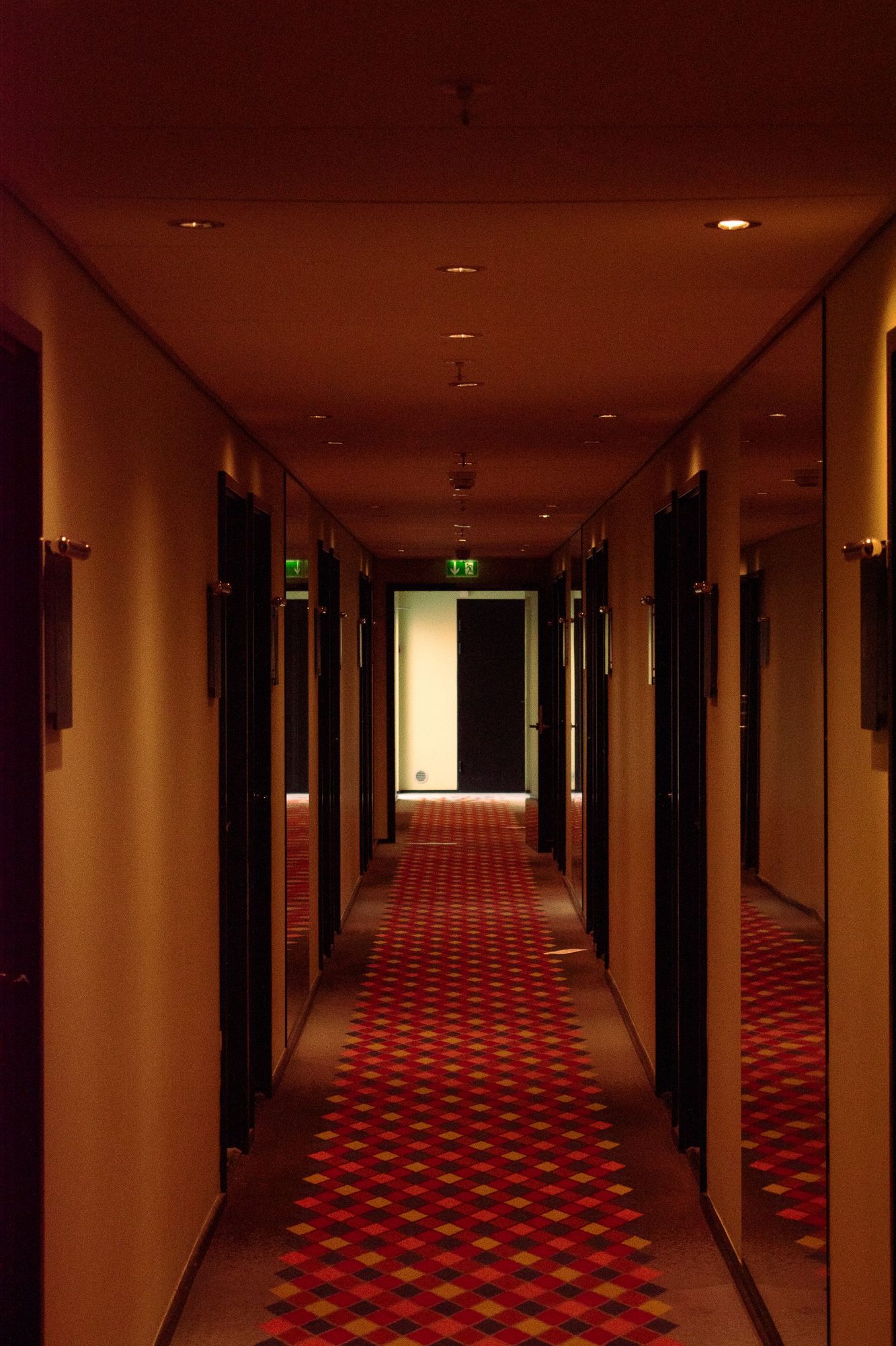 Beleuchteter Hotelkorridor mit Zimmertüren