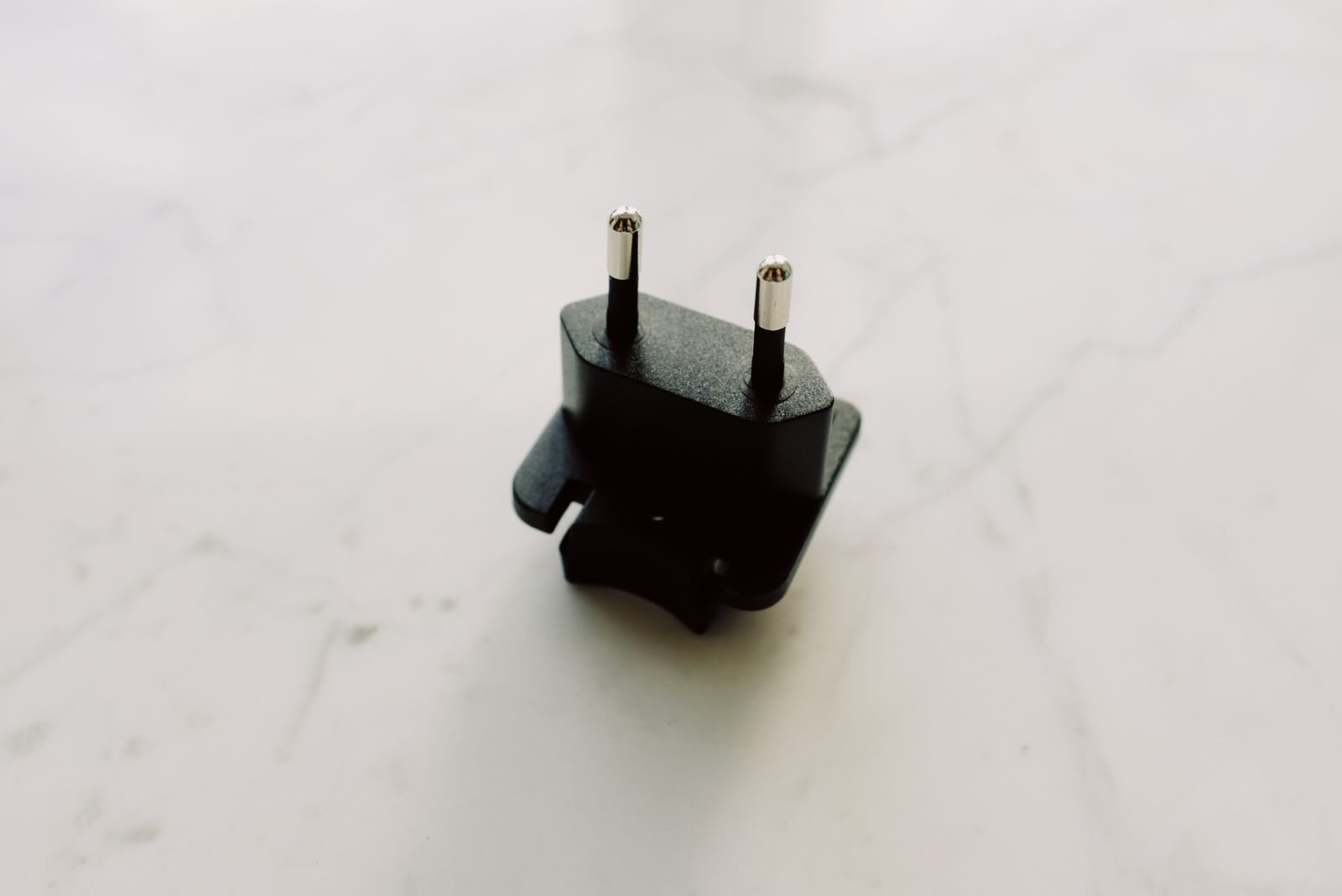 Elektrischer Reiseadapter auf einer hellen Fläche